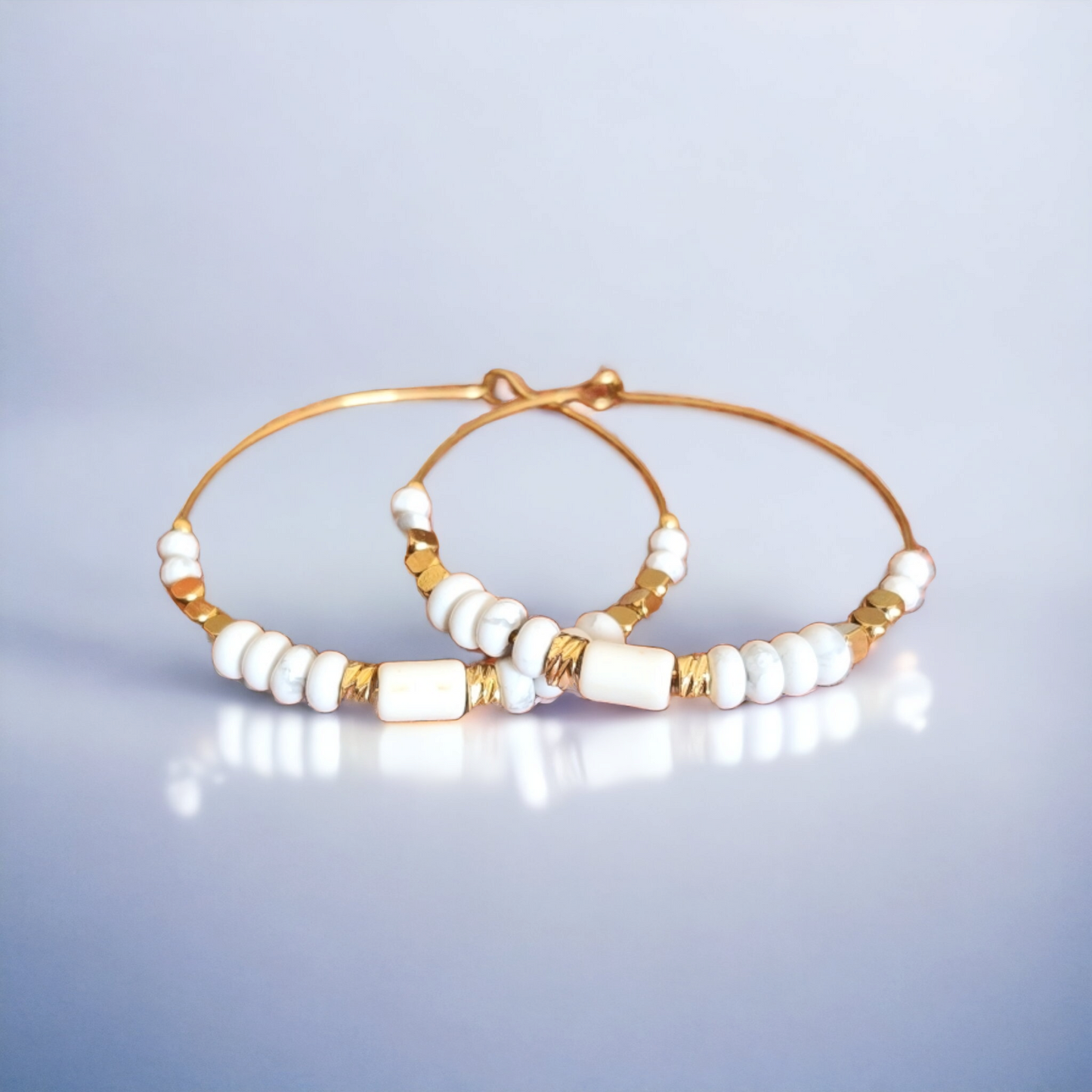 Explorez la tranquillité de la howlite avec nos boucles d'oreilles créoles. Chaque paire est une invitation à la paix intérieure et à l'élégance sereine. Portez les avec fierté pour ajouter une touche de calme et de raffinement à votre quotidien. Élégance Apaisante : Nos boucles d'oreilles créoles en howlite sont une célébration de la sérénité de cette pierre précieuse. Chaque paire est conçue avec soin pour mettre en valeur la douceur des nuances blanches marbrées de gris de la howlite.