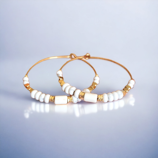 Explorez la tranquillité de la howlite avec nos boucles d'oreilles créoles. Chaque paire est une invitation à la paix intérieure et à l'élégance sereine.  Portez les avec fierté pour ajouter une touche de calme et de raffinement à votre quotidien.  Élégance Apaisante : Nos boucles d'oreilles créoles en howlite sont une célébration de la sérénité de cette pierre précieuse. Chaque paire est conçue avec soin pour mettre en valeur la douceur des nuances blanches marbrées de gris de la howlite.